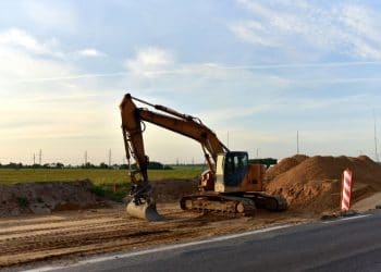 Excavator On Earthworks and Road Construction in City. Temporary Traffic Regulation from carrying out road works or activity on the public highway. Roadway Work Zone Safety. Out of focus, motion blur